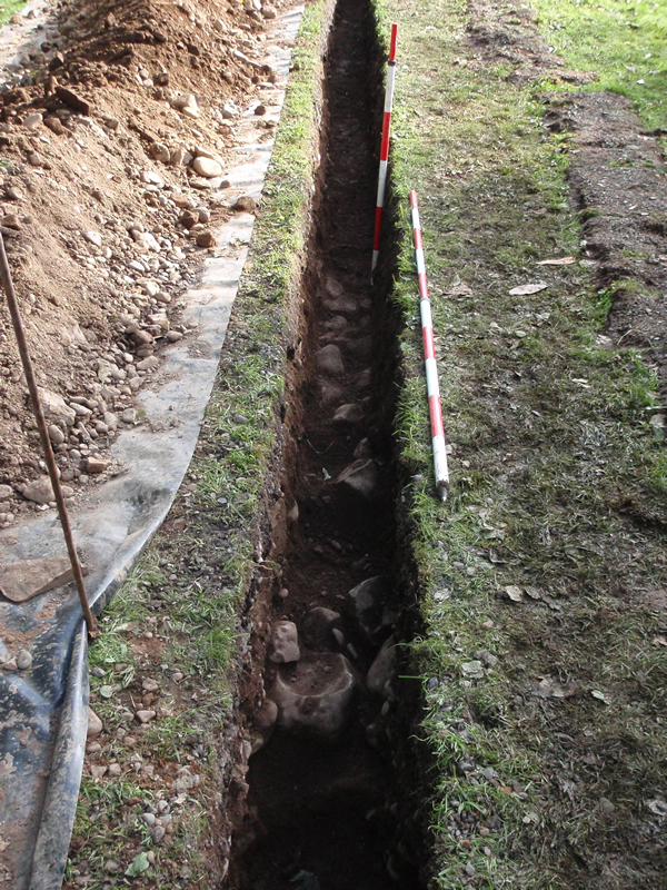 View of one of the trenches with a barrack wall and cobbled surface showing